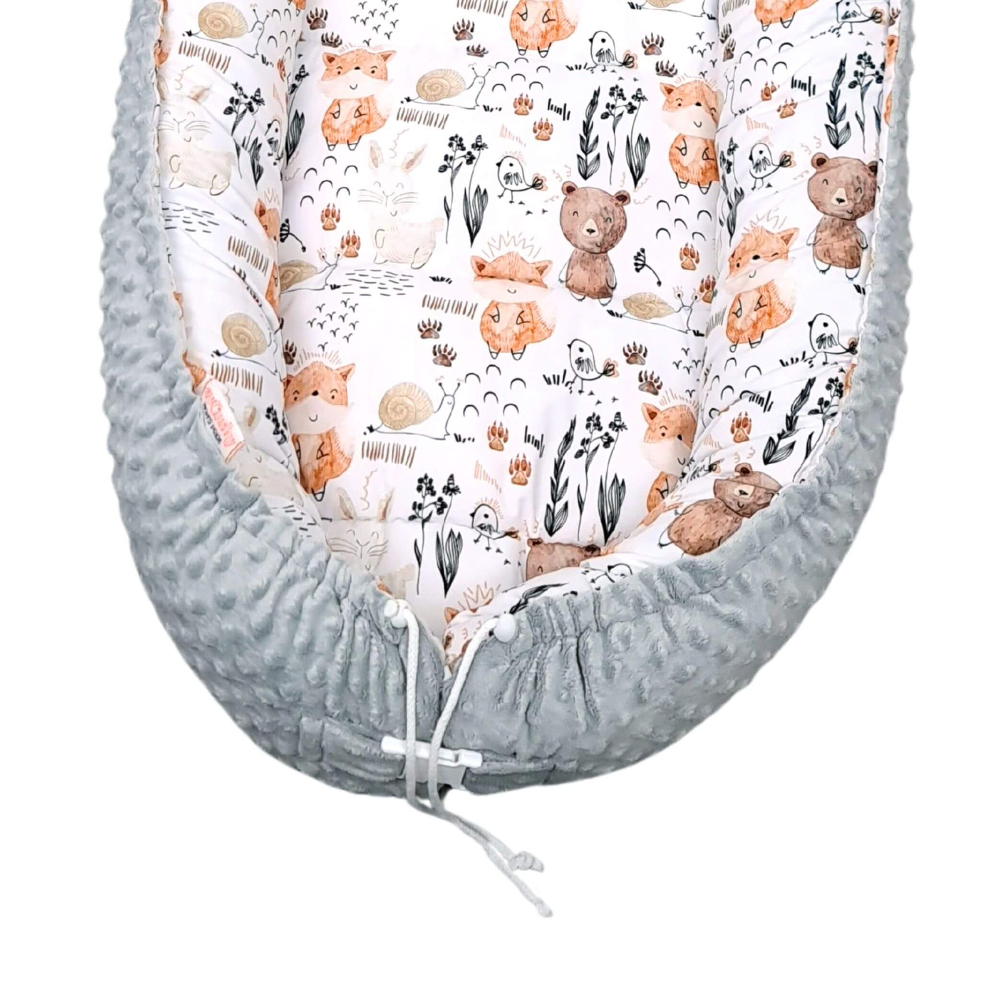 close up of cosy baby sleep bed hand-made eco freindly nest plush grey and woodland animals pattern