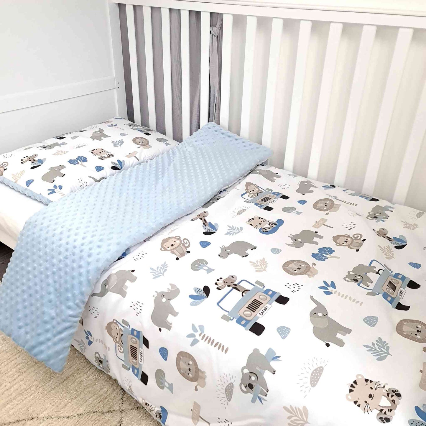 Baby duvet and pillow set made of soft cotton and plush blue fabric, featuring a safari pattern with animals and a jeep – cozy bedding for nurseries.