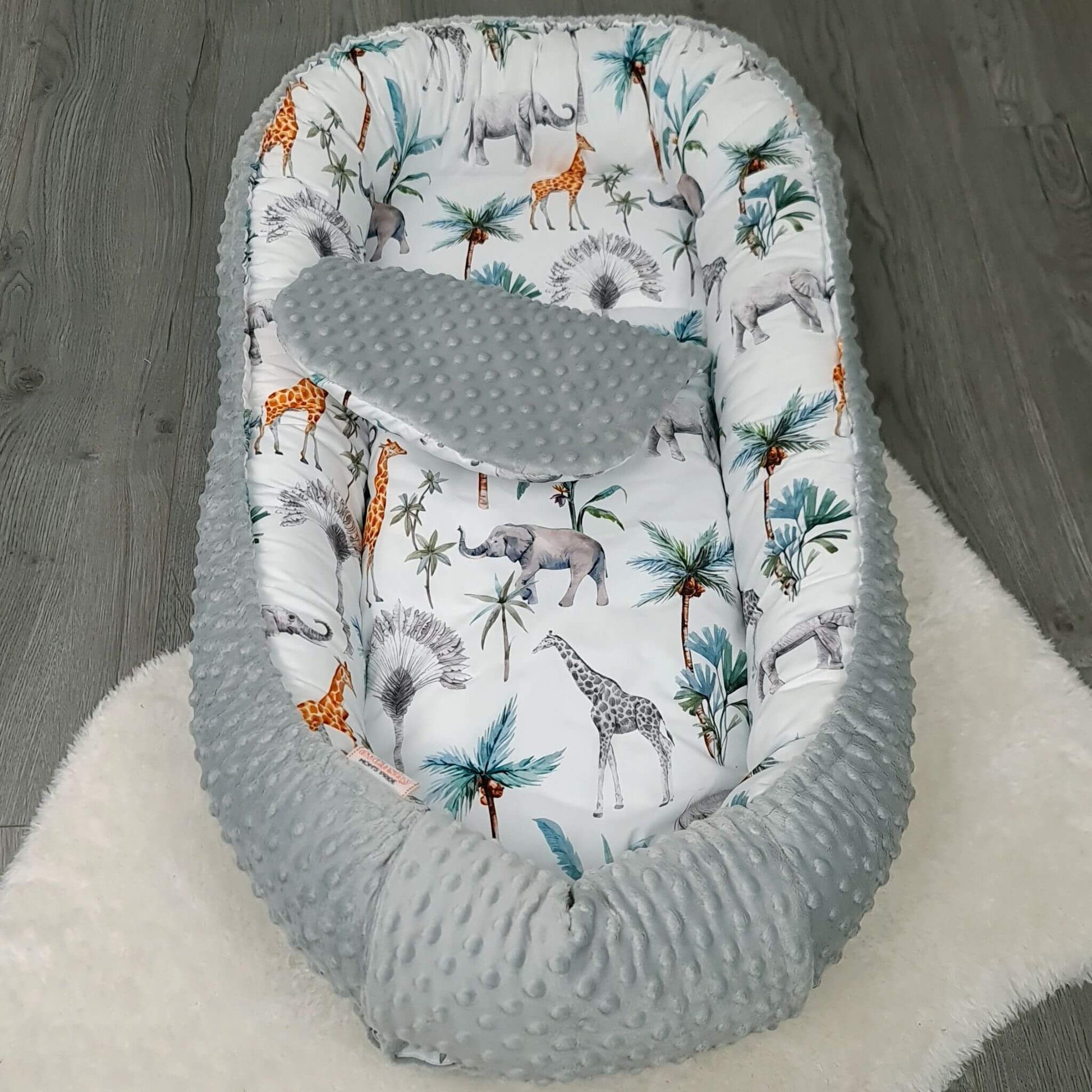 Safari pattern toddler nest with soft liner, ideal for naps and playtime.