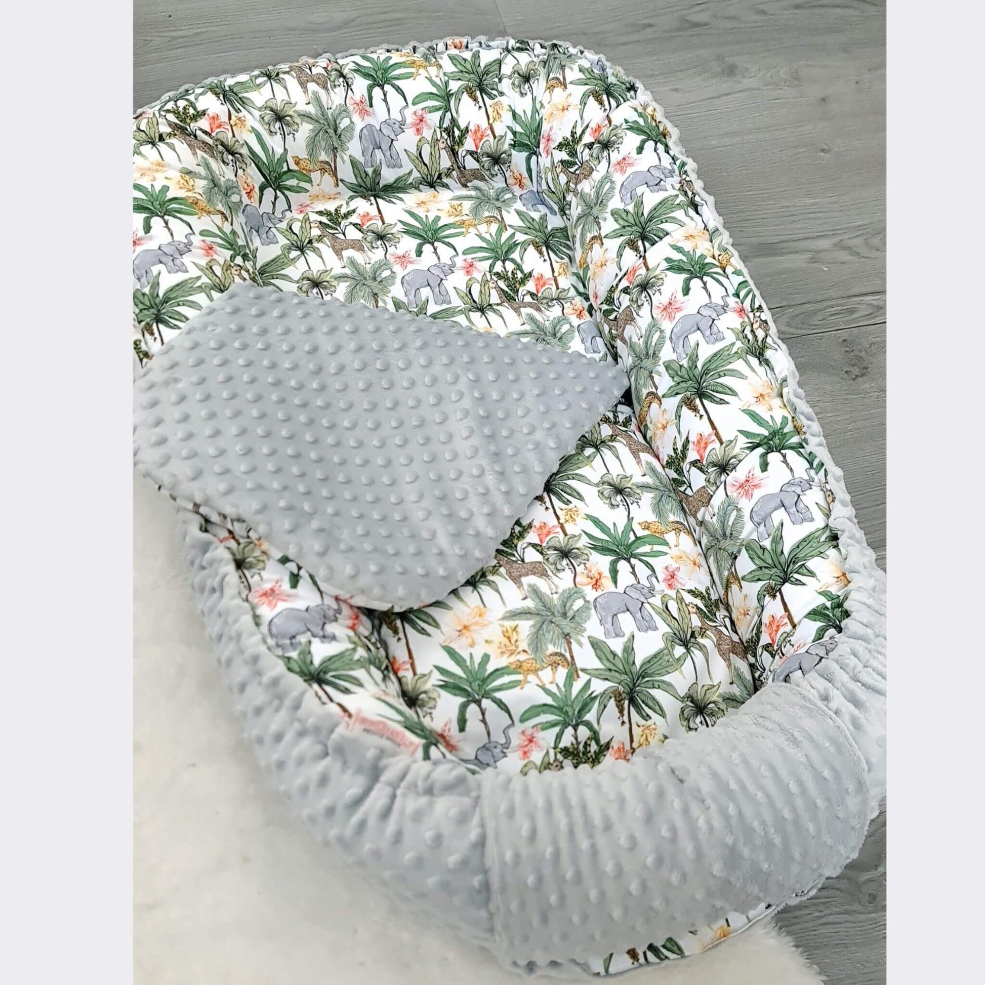 Toddler nest made of breathable cotton and cozy dimple plush, reversible with jungle print design.