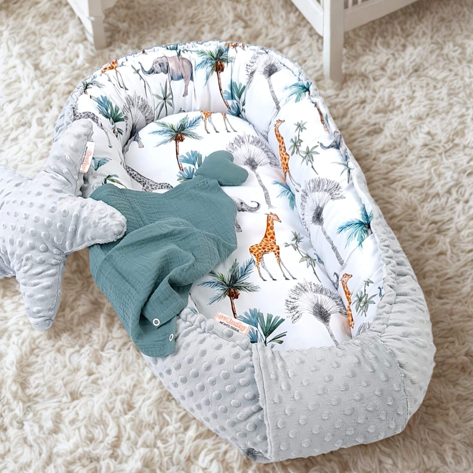 baby nest for newborn grey plush minki fabric and 100% cotton safari jungle animals pattern lying on the floor in baby nursery