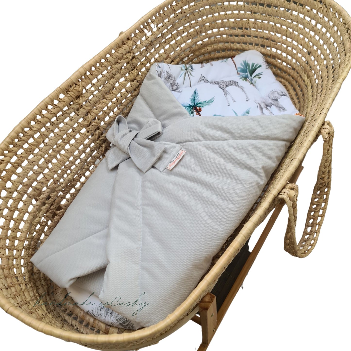 multi-functional 3-in-1 swaddle blanket, featuring a stylish grey exterior and a delightful safari animal pattern on the inside. It is elegantly tied with a bow for added charm.