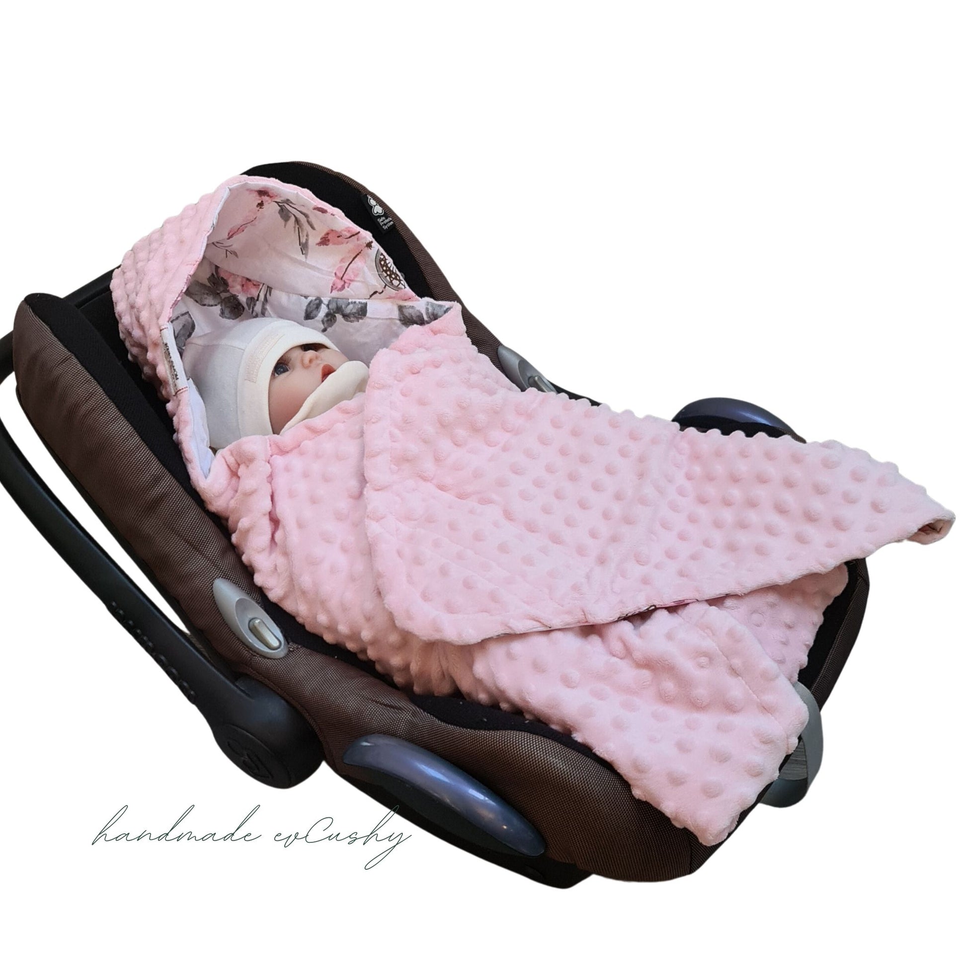 Image: A pink hooded blanket designed for newborn baby girls, perfectly sized to fit car seats. Pink and floral design with dreams catchers and roses