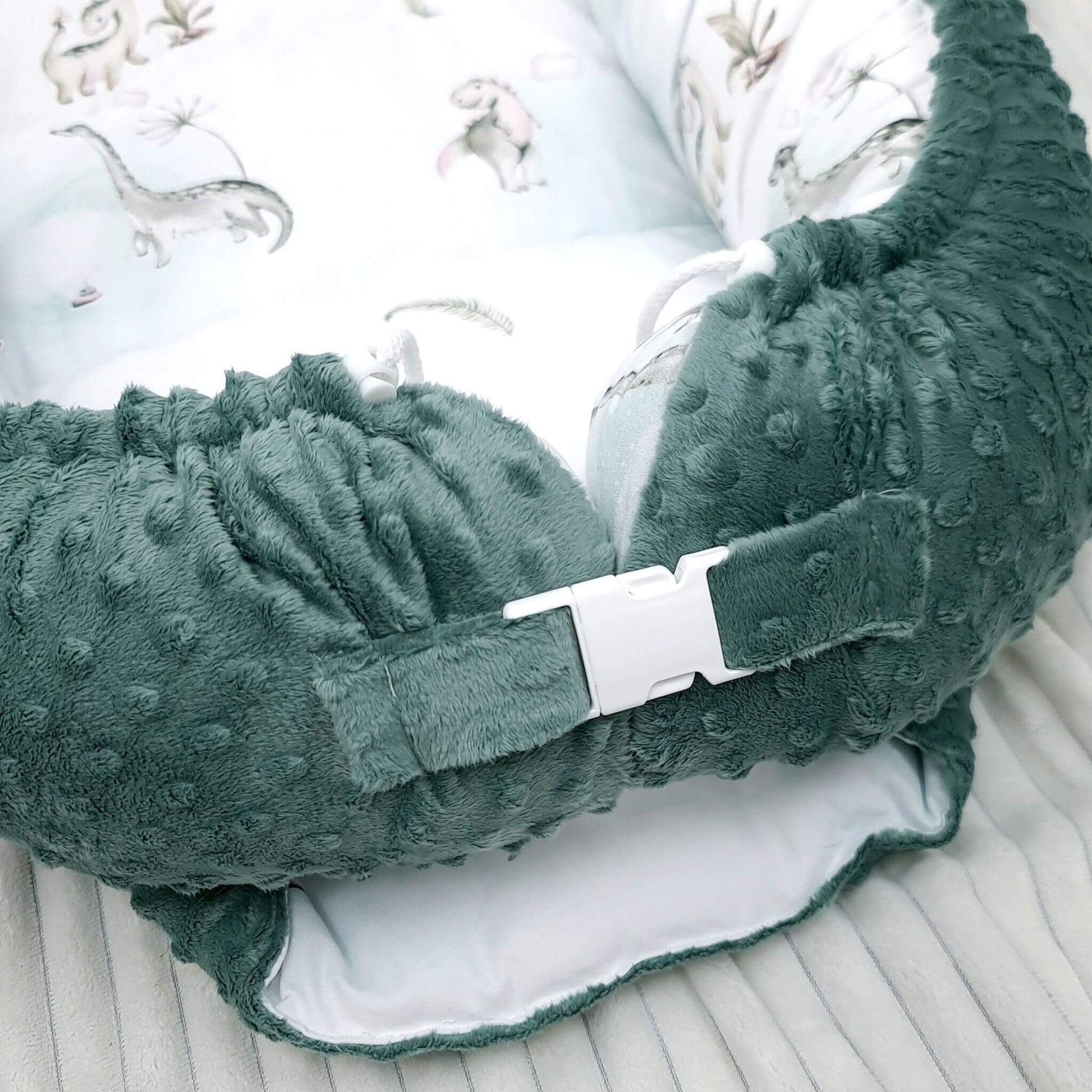 Side view showing adjustable buckle and drawstrings on Dino Adventure baby nest XXL