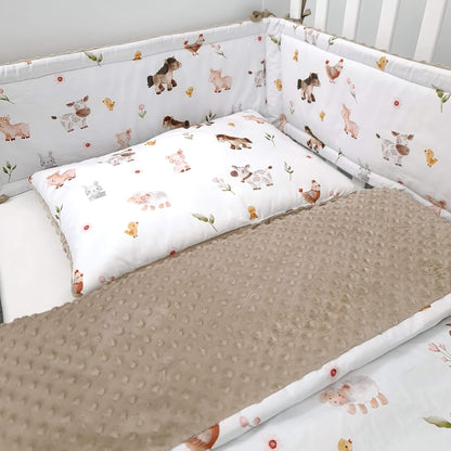 Close-up of Farm Friends quilt and pillow with ponies, cows, and bunnies and brown minky blanket and cot bed bumper for cot size 140x70cm
