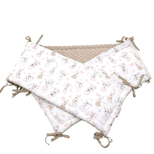 Close-up of retro bunny cotton fabric and ribbon bow details on cot bumper for baby girl