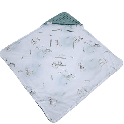 Close-up of Tiny Roars dinosaur and floral cotton pattern in soft green and white from Evcushy blanket collection