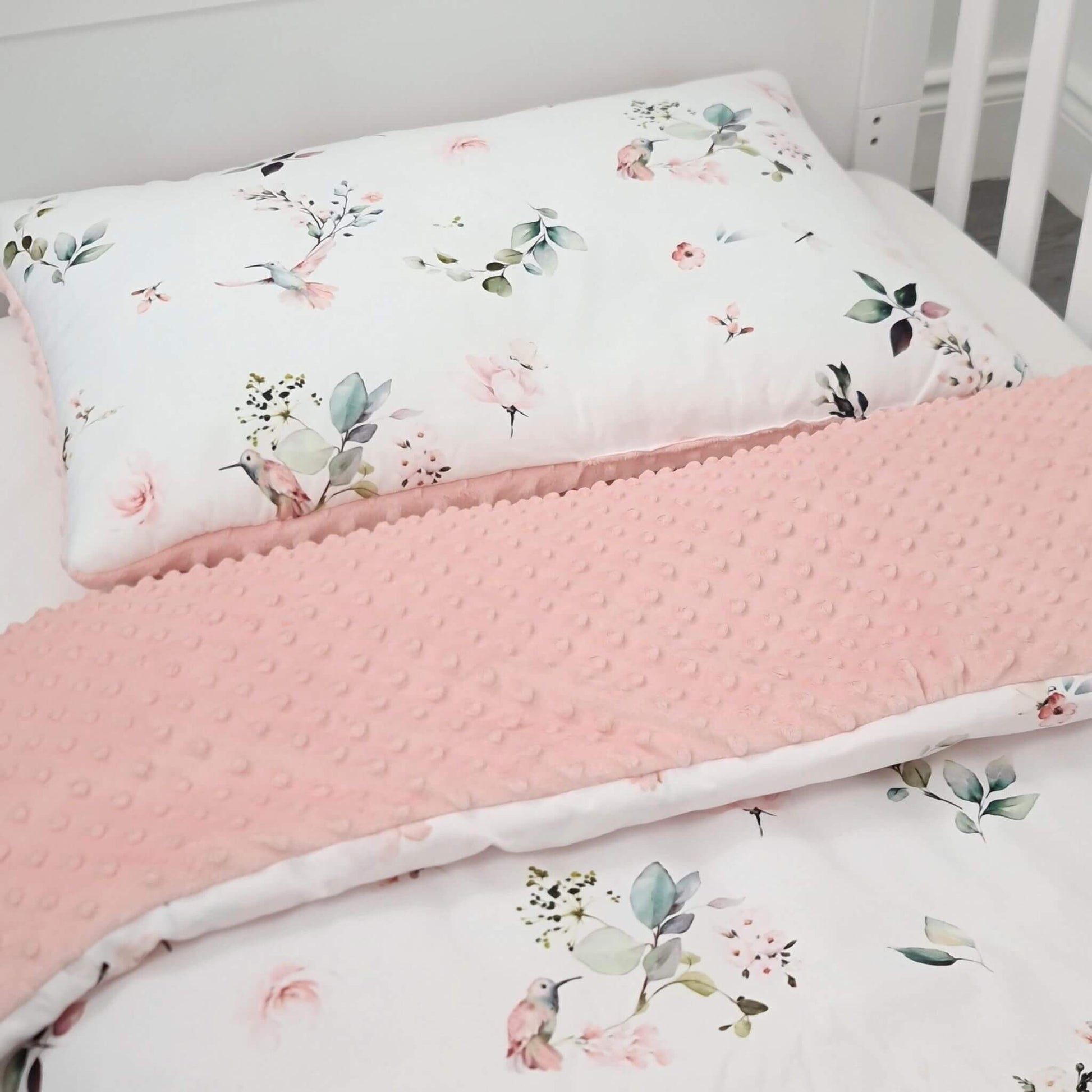Floral-patterned pillow and bedding set on a bed with a white background for toddler baby girl