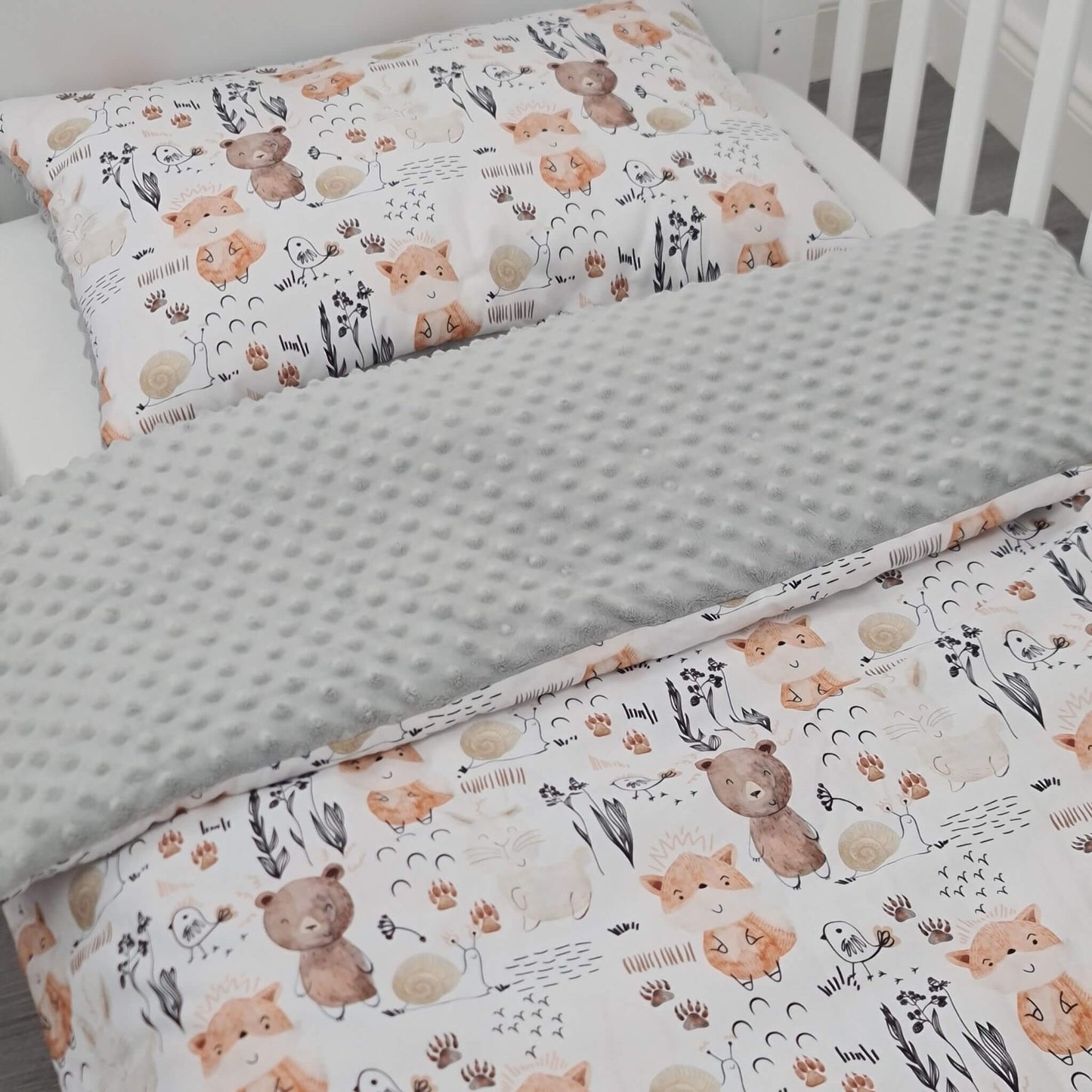 Children's bedding set with bear pattern on a crib Close-up of Woodland Forest quilt and pillow made of soft cotton and fleece