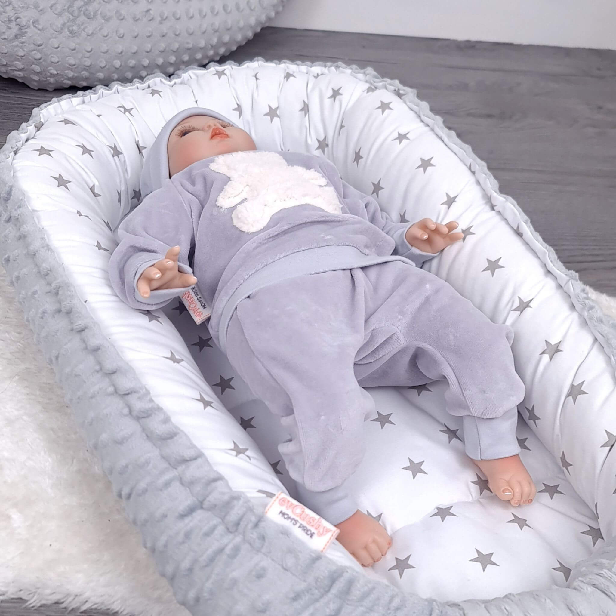 Newborn baby relaxing in grey stars baby nest with soft grey minky fabric – cosy handmade baby lounger by Evcushy