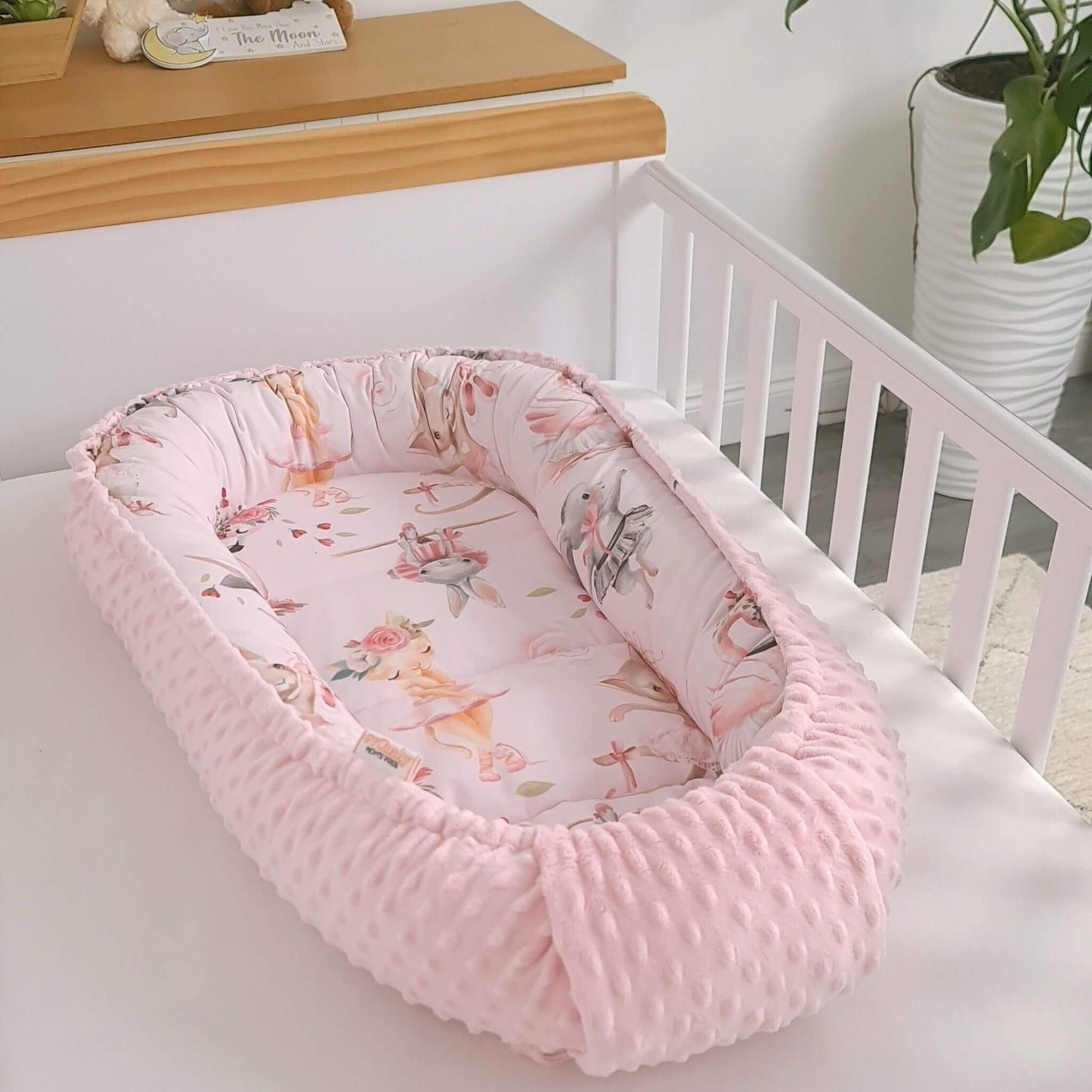 Newborn baby nest cocoon in soft pink tones