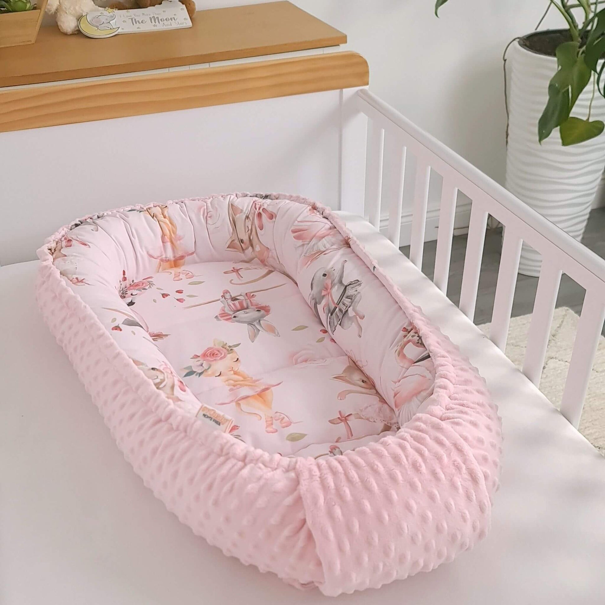 Newborn baby nest cocoon in soft pink tones