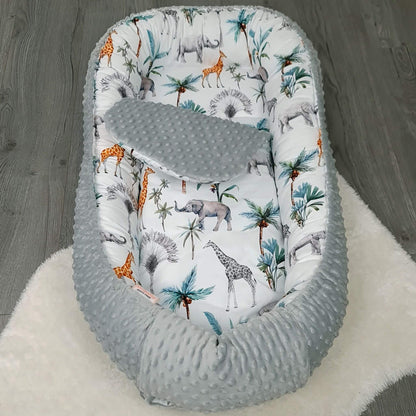 Safari pattern toddler nest with soft liner, ideal for naps and playtime.