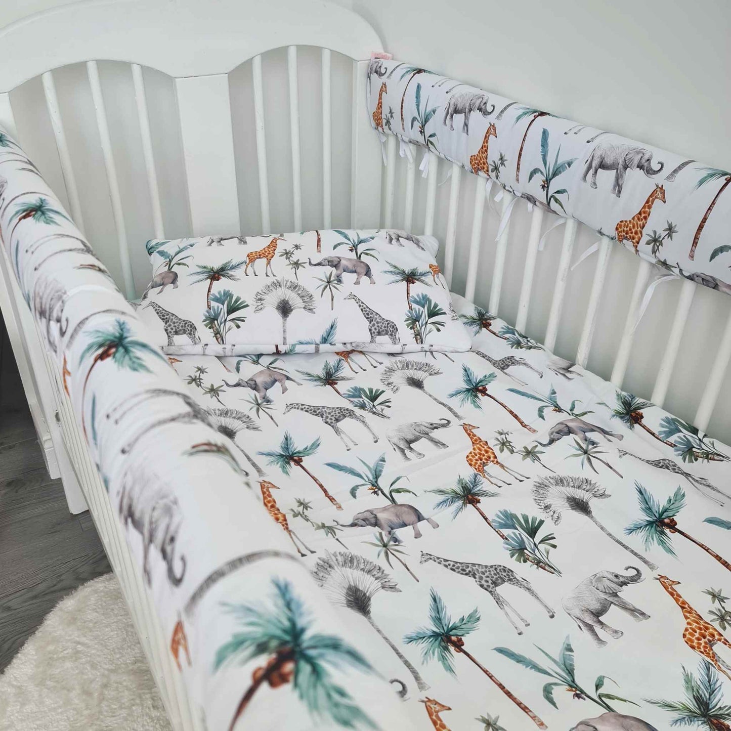 baby cot bed white with bedding safari pattern and cot bumpers 